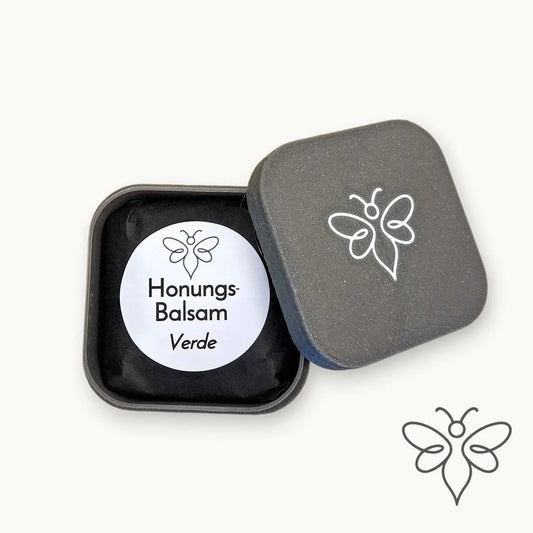Öppen grå förvaringsask med EneboBee Honungsbalsam Verde och lock med vit bilogga.