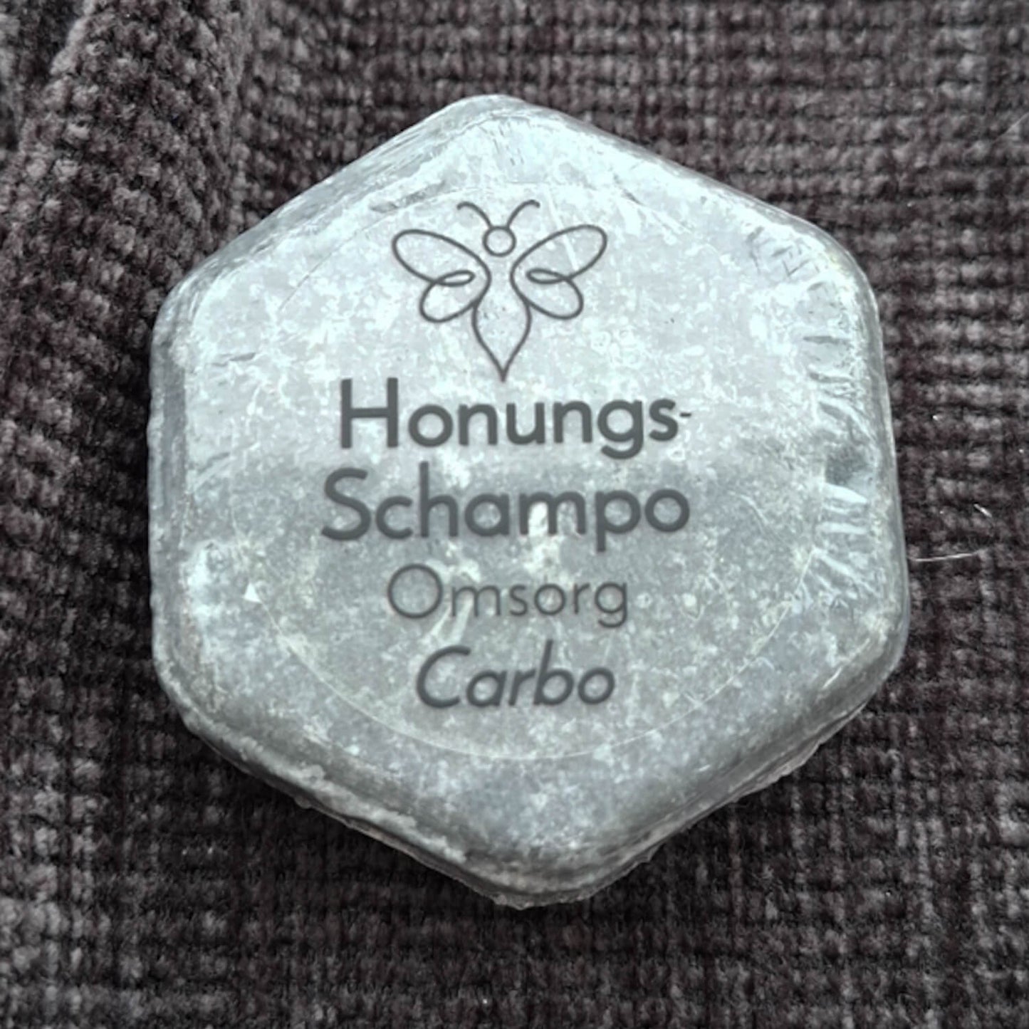 EneboBees HonungsSchampo, Omsorg, med doften Carbo i transparent förpackning.