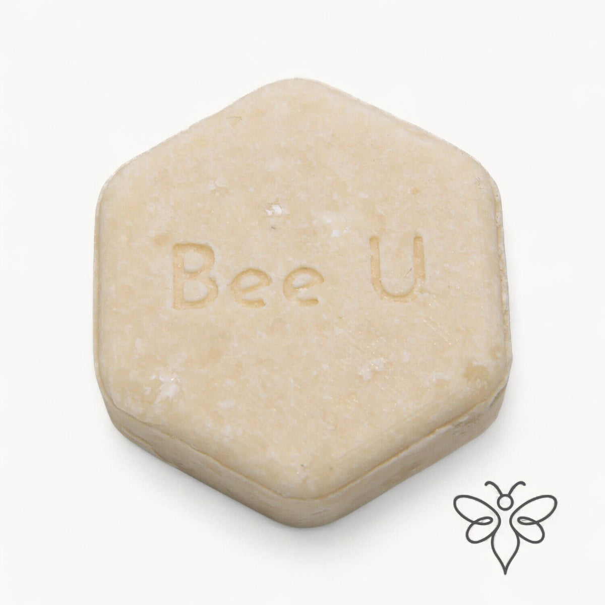 EneboBee schampokaka Balans Alba, handgjort honungsschampo, en cremevit melerad hexagon.
