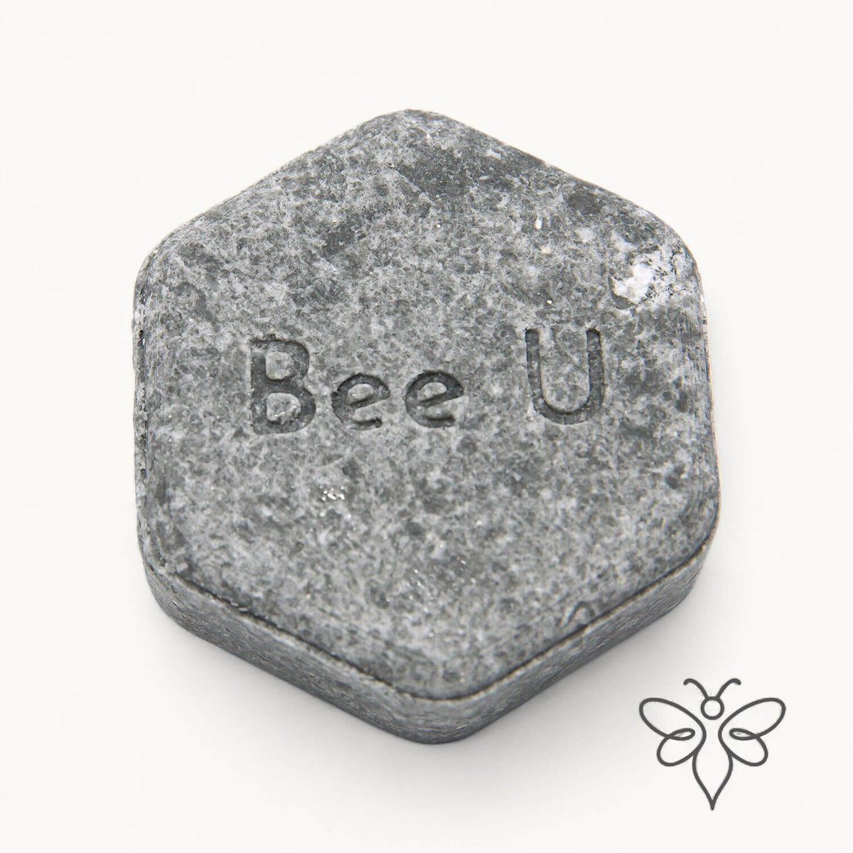 EneboBee schampokaka Balans Carob, handgjort honungsschampo, en gråmelerad hexagon.