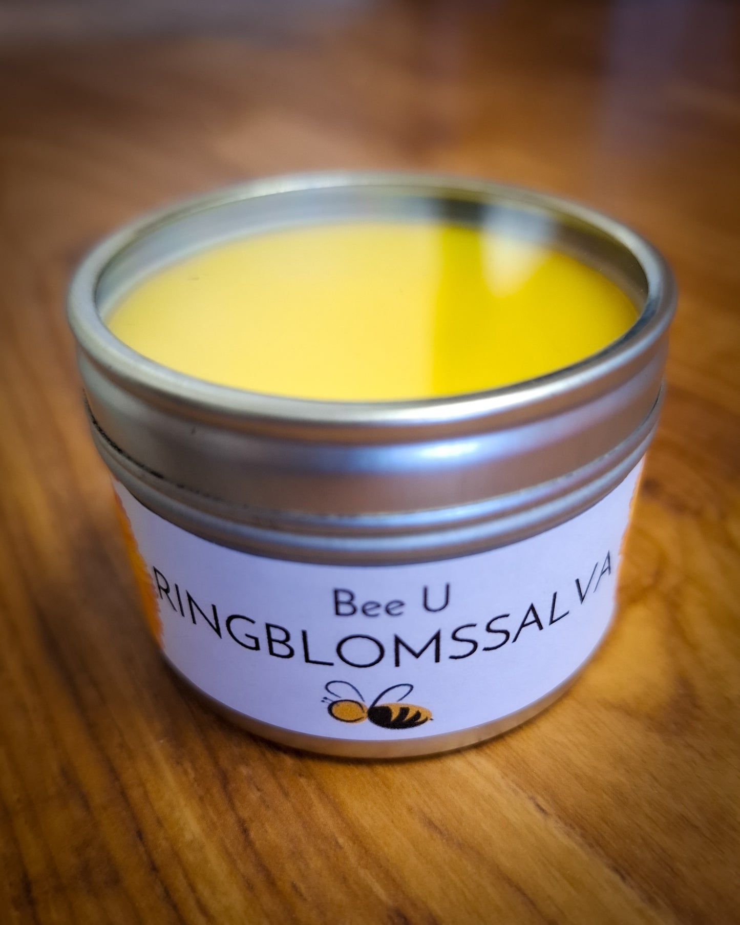 Bivaxsalva - Ringblomssalva, framsida på träbakgrund, annan vinkel