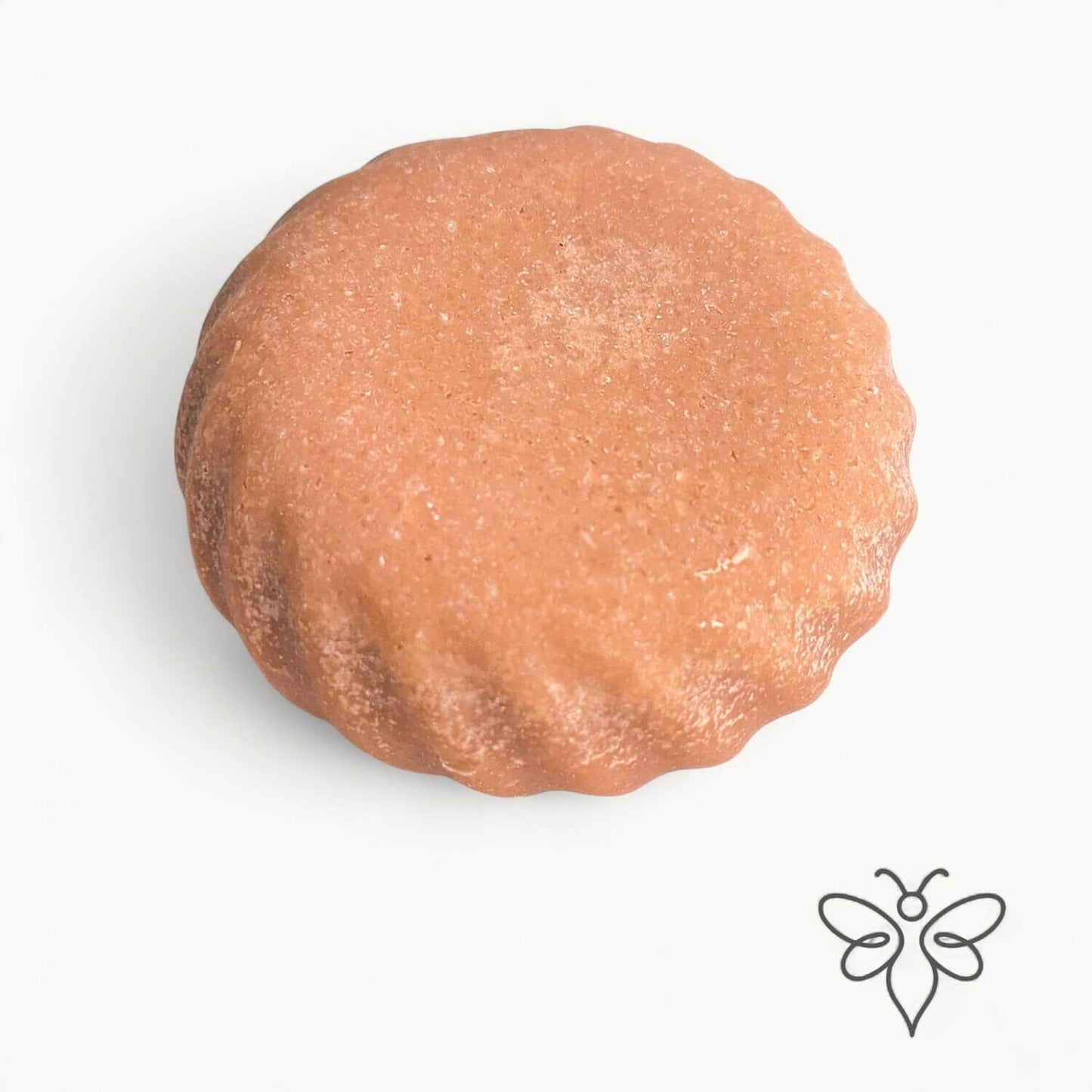 EneboBee honungstvål med havssalt – Rubra – en tegelröd rund handgjord tvål med vågig kant.