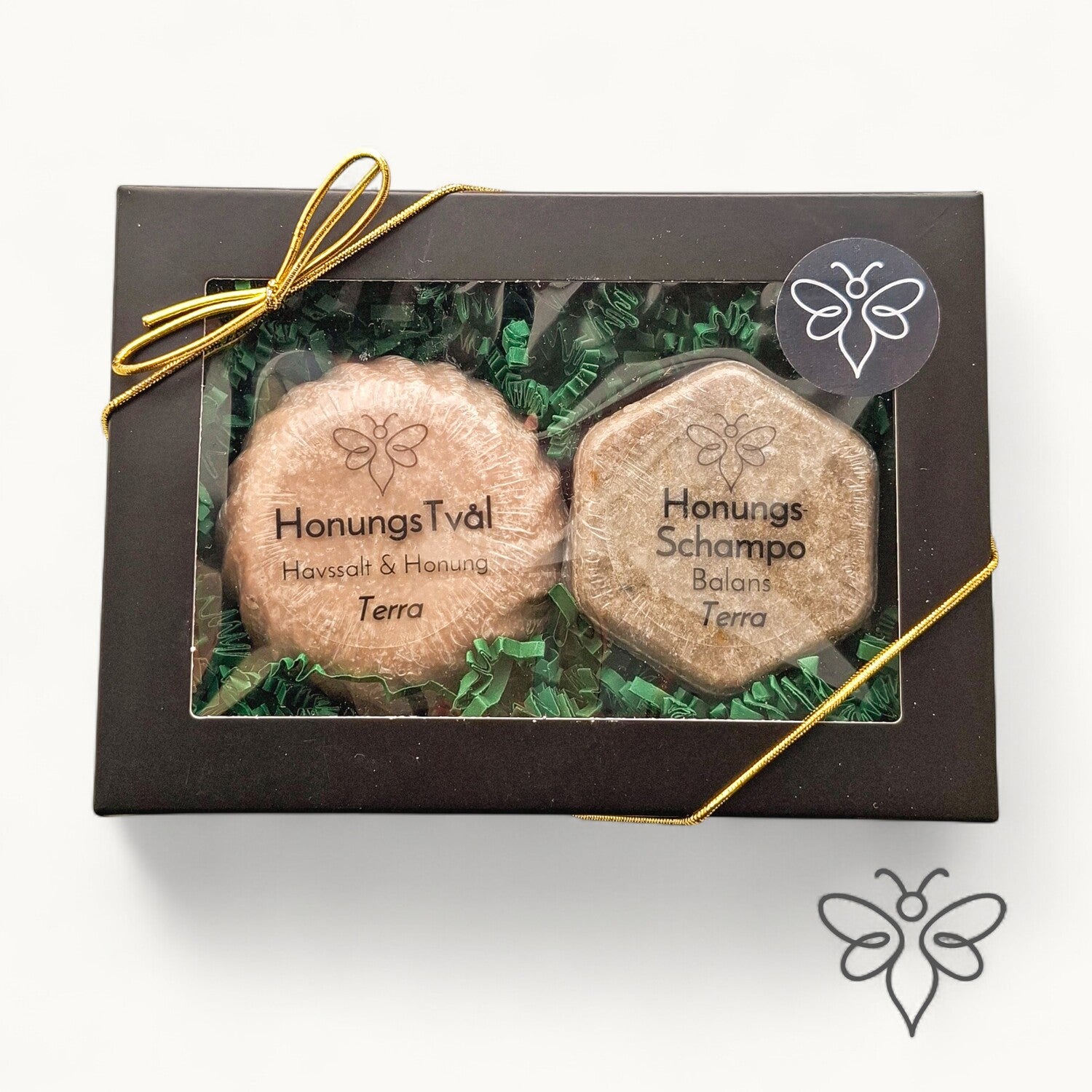 Stängd presentask, Terra, med honungstvål och schampokaka från EneoBee, svart ask med fönster och guldsnöre.