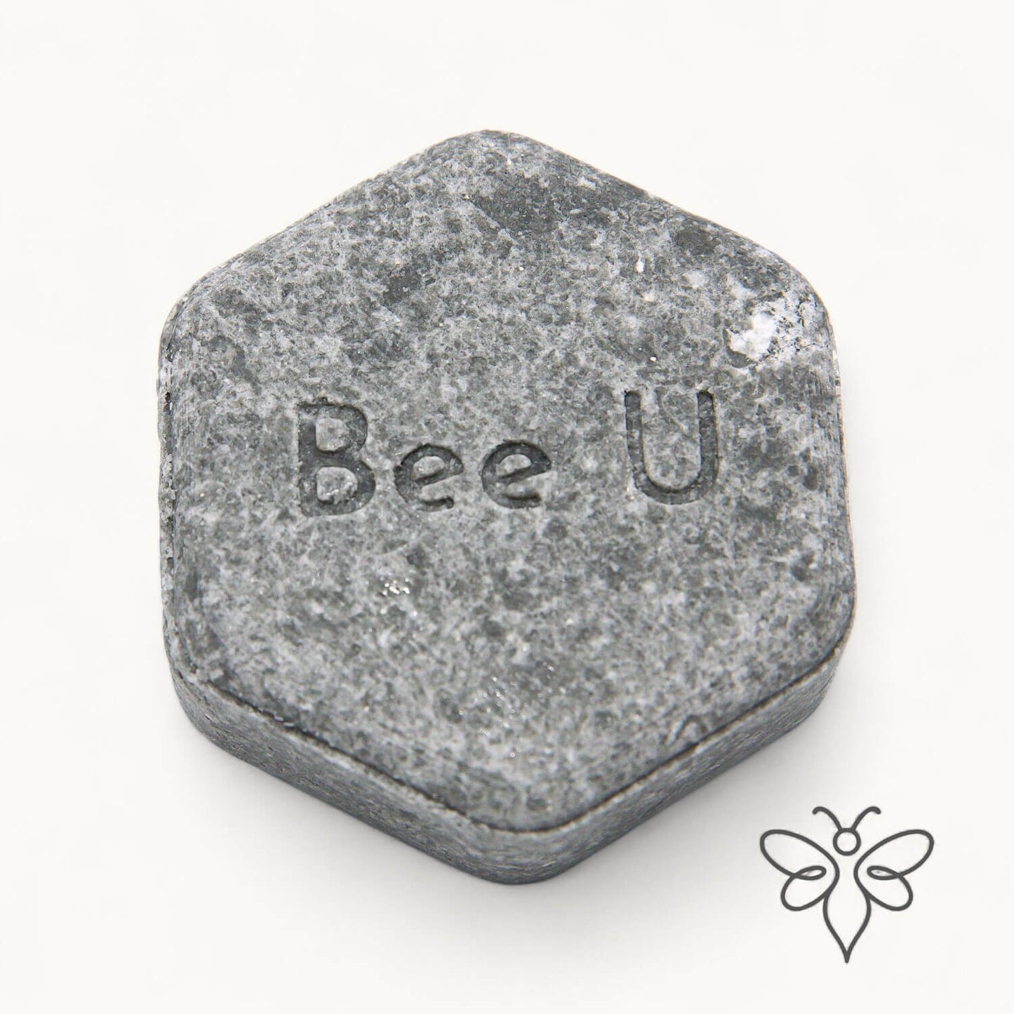EneboBee schampokaka Balans Carob, handgjort honungsschampo, en gråmelerad hexagon.
