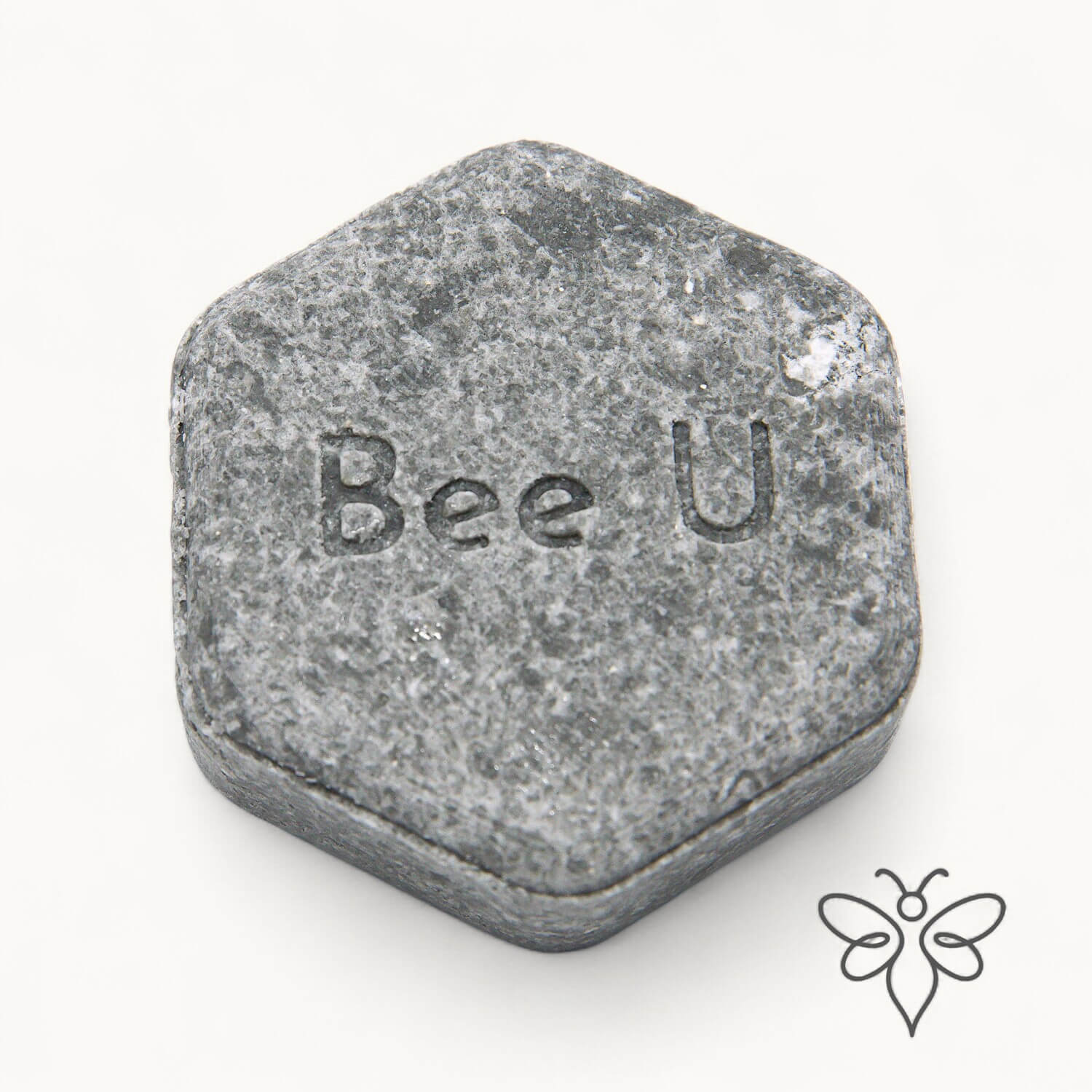EneboBee schampokaka Balans Carob, handgjort honungsschampo, en gråmelerad hexagon.