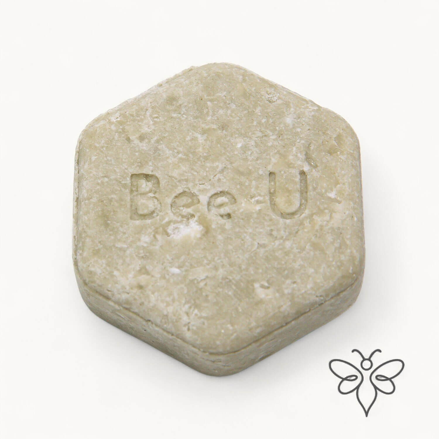 EneboBee schampokaka Balans Verde, handgjort honungsschampo, en ljust olivgrön melerad hexagon.