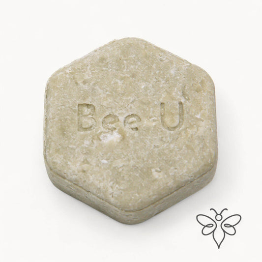 EneboBee schampokaka Balans Verde, handgjort honungsschampo, en ljust olivgrön melerad hexagon.