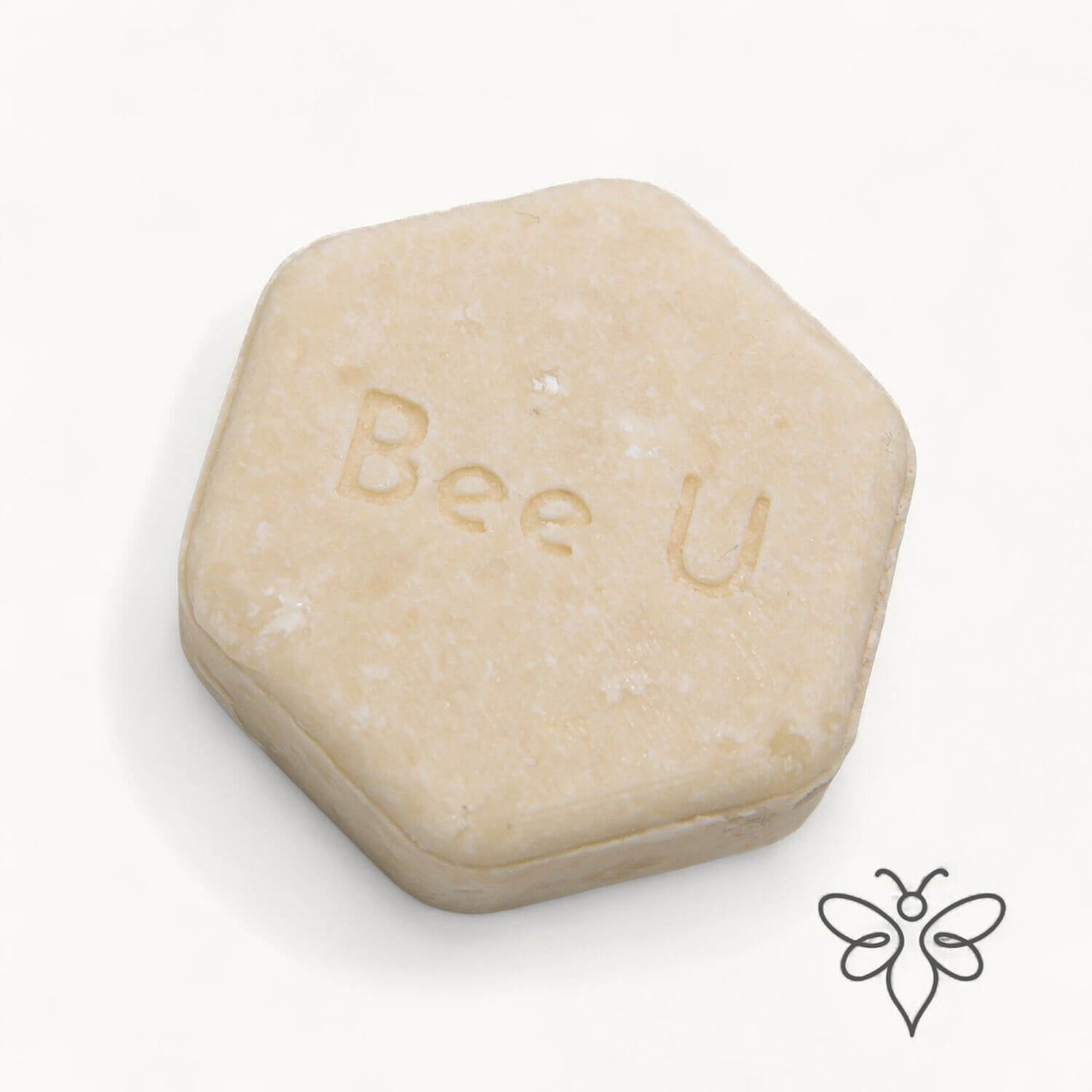 EneboBee schampokaka Omsorg Alba, handgjort honungsschampo, en cremevit melerad hexagon.