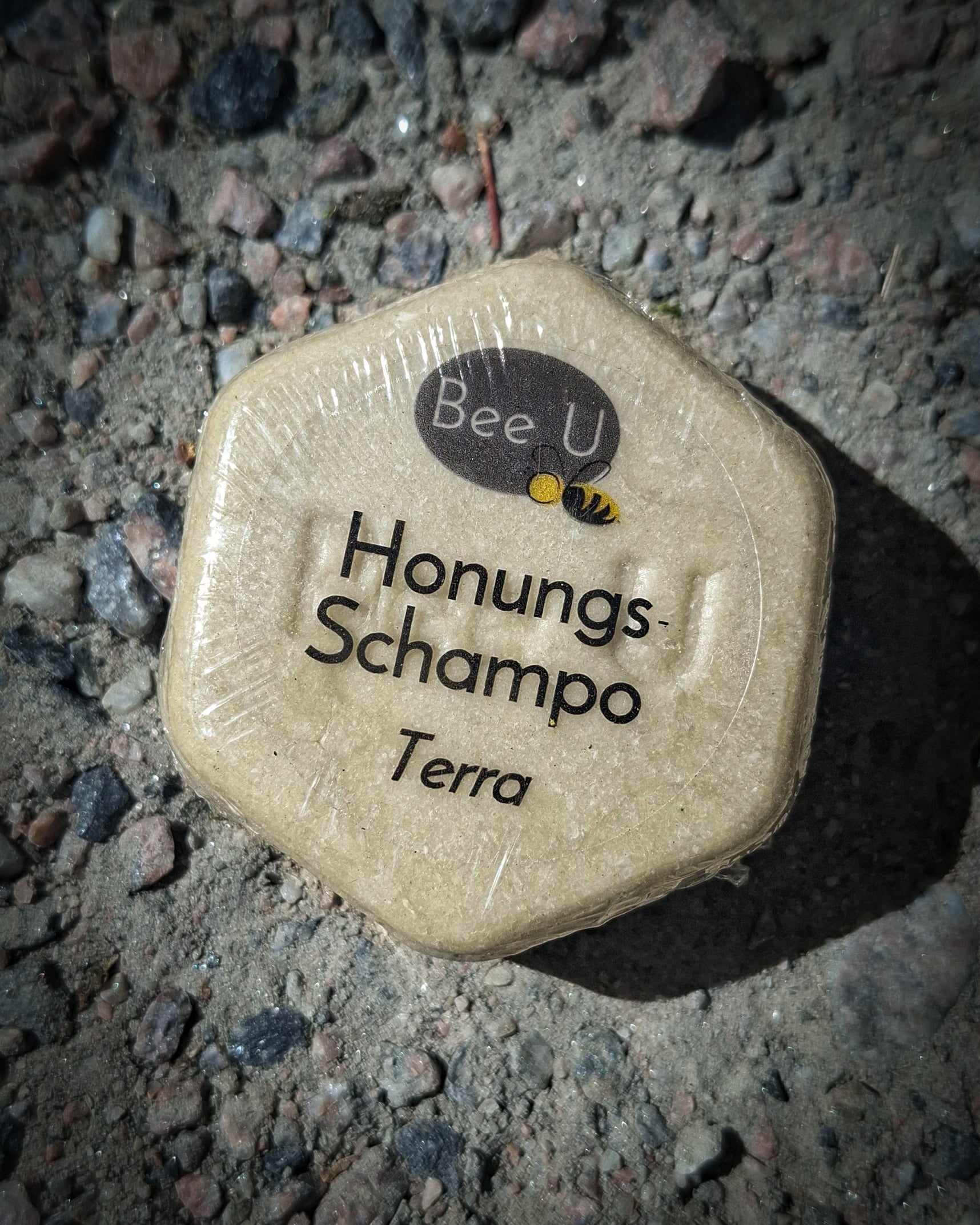 Schampokaka – Honungsschampo – Omsorg – Terra, framsida på grusbädd